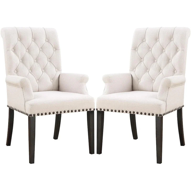 Silla de comedor beige con brazos, respaldo curvo con botones capitoné y ribete de tachuelas