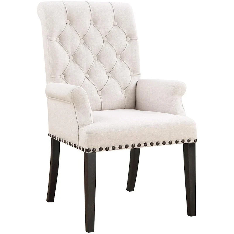Silla de comedor beige con brazos, respaldo curvo con botones capitoné y ribete de tachuelas
